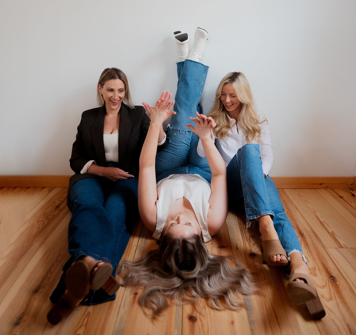 Three partners, Blonder Marketing sitting on floor high fiving